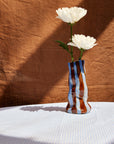 Decorative vase with white flowers on a textured surface