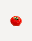 Glossy red handmade ceramic tomato, crafted from stoneware in Spain – a lifelike artisan accent for rustic or modern interiors.