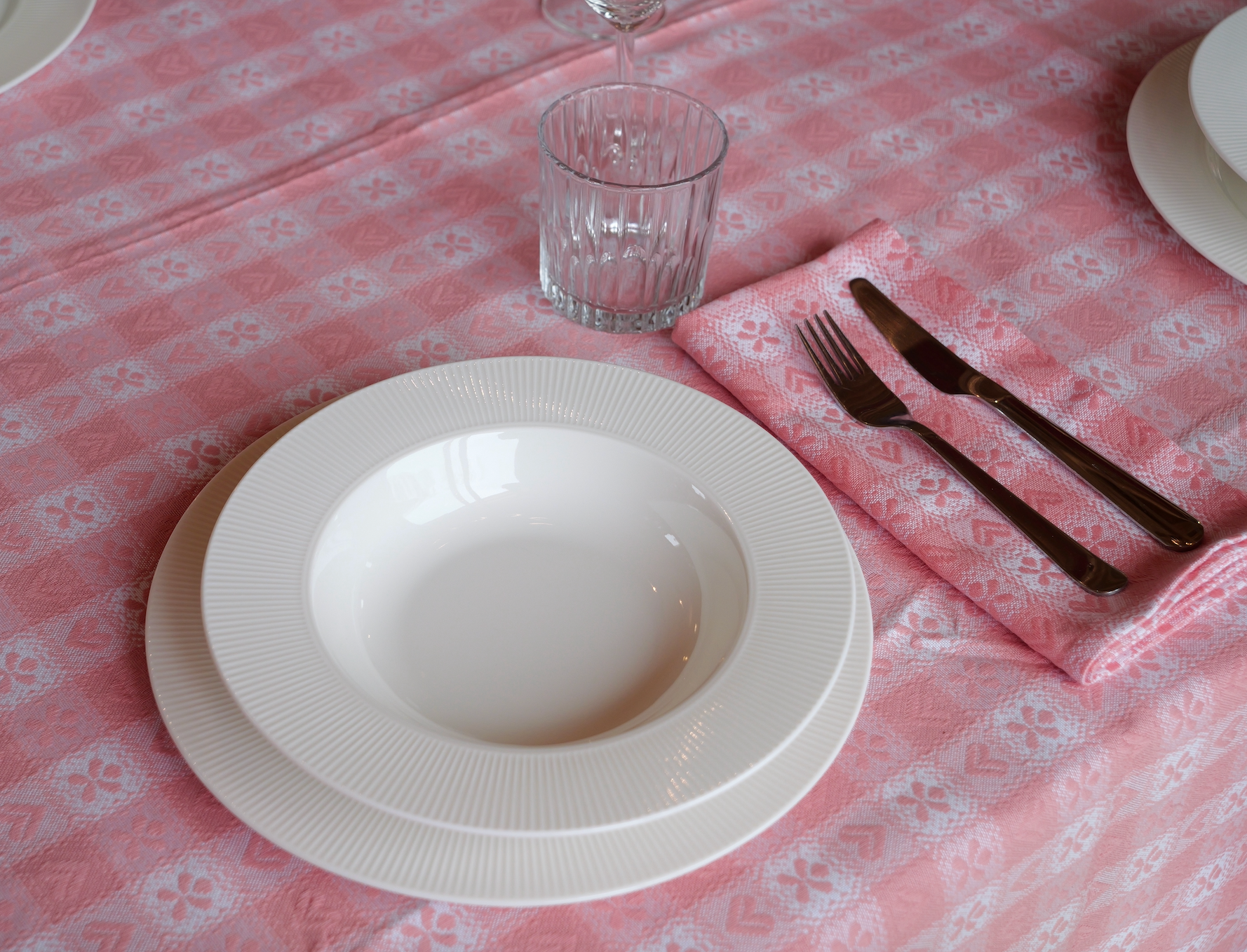 Pink and white gingham chalet napkin with heart and floral motifs, crafted in Italy from Oeko-Tex certified cotton.