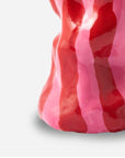 Sculptural ceramic vase by Marla Primrose with an organic, twisted silhouette, hand-painted in glossy red and pink candy stripes.