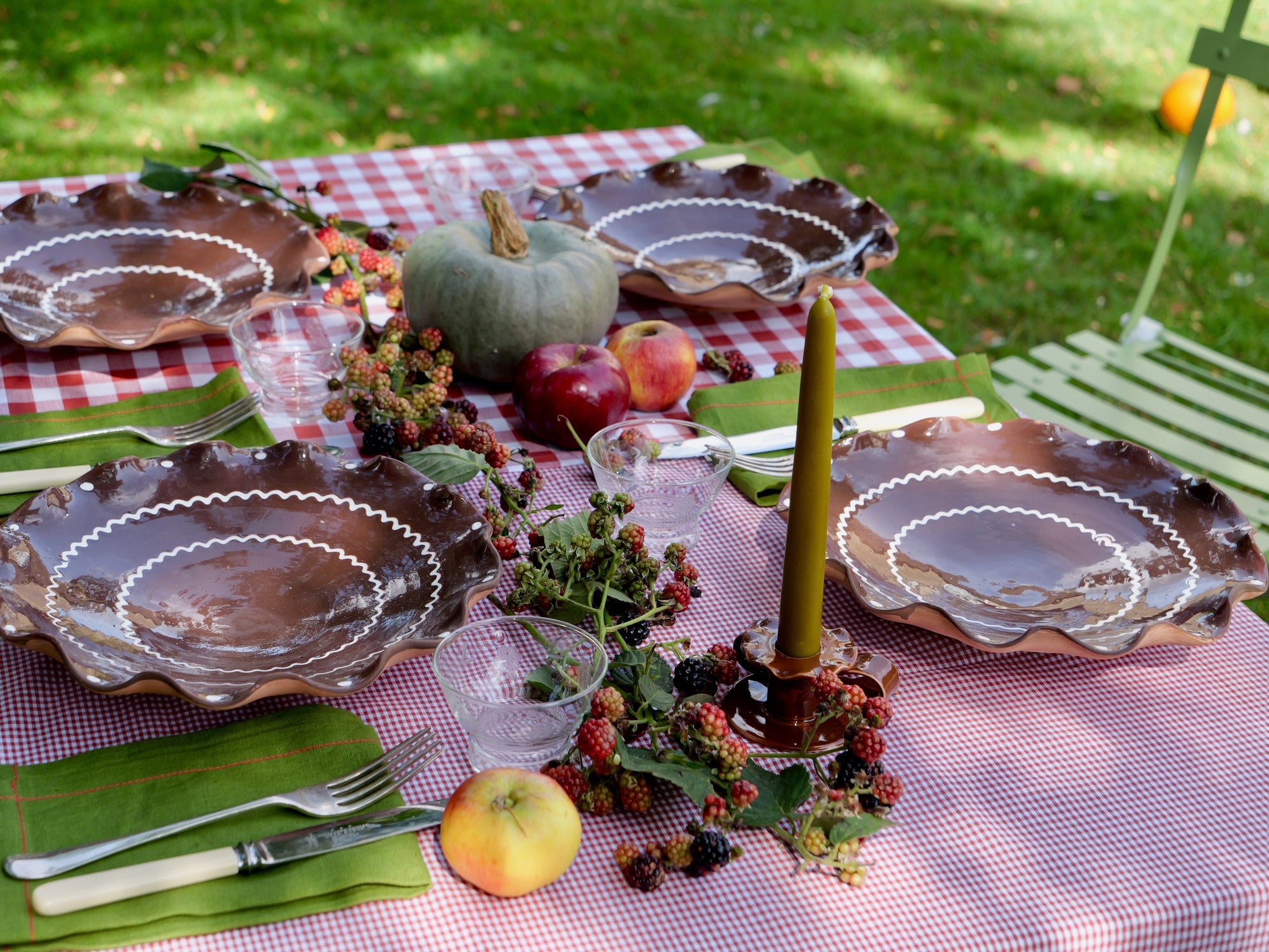 Marla Primrose Autumnal Table with gingham red tablecloth, apples, handmade plates and bow candle holders