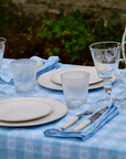 Blue and white gingham chalet napkin with heart and floral motifs, crafted in Italy from Oeko-Tex certified cotton.