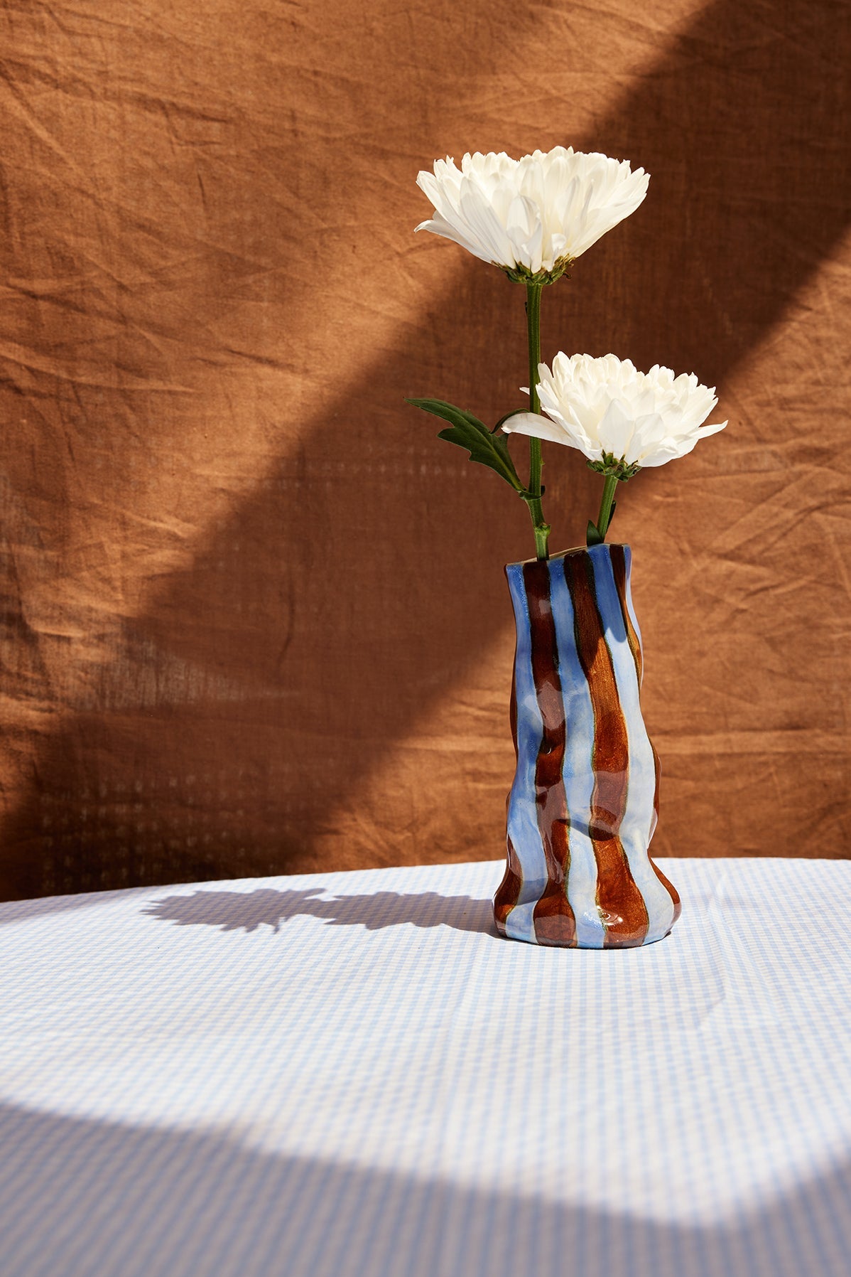 Decorative vase with white flowers on a textured surface