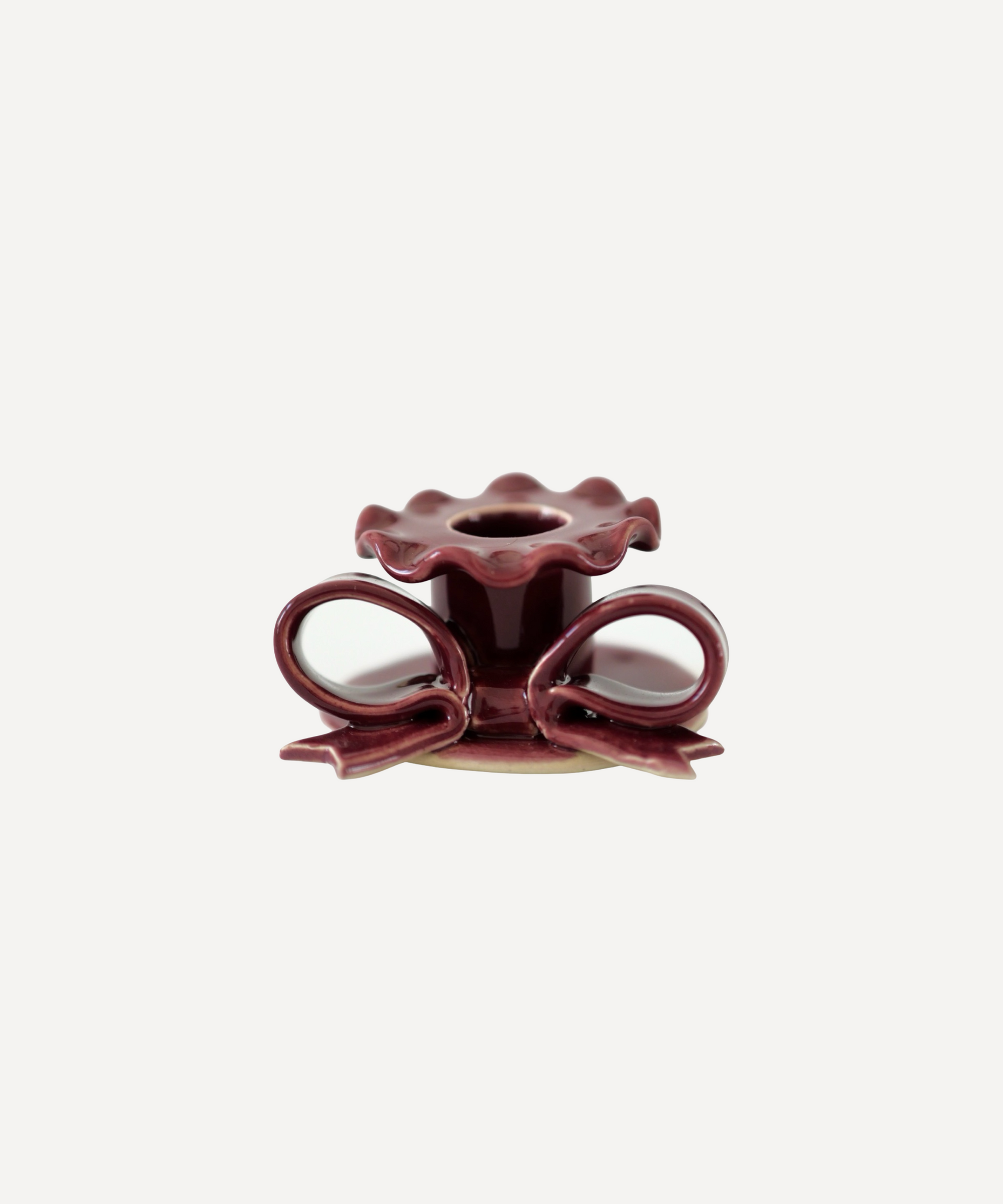 Handmade ceramic bow candle holder in burgundy red finish, fits taper candles.