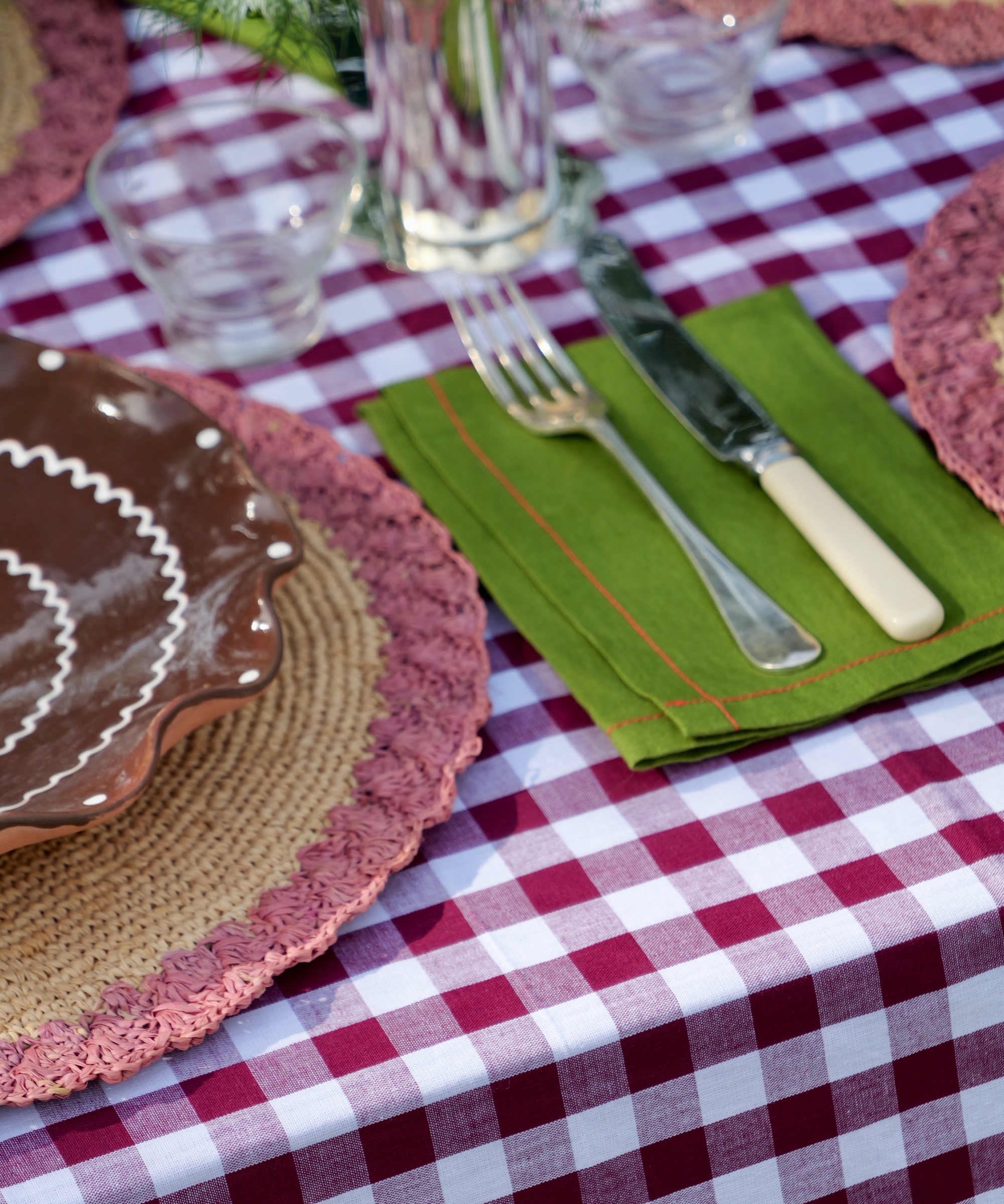High-quality 100% linen napkin in forest green with red stitch detail, sold individually.