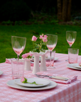 Marla Primrose Alpine Pink Chalet Napkin folded on a rustic wooden table, evoking cozy mountain dining.